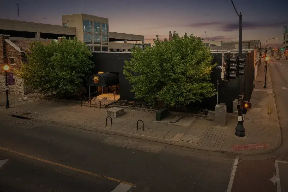 The Opus building at dusk, seen down West McDaniel with the street lights on.