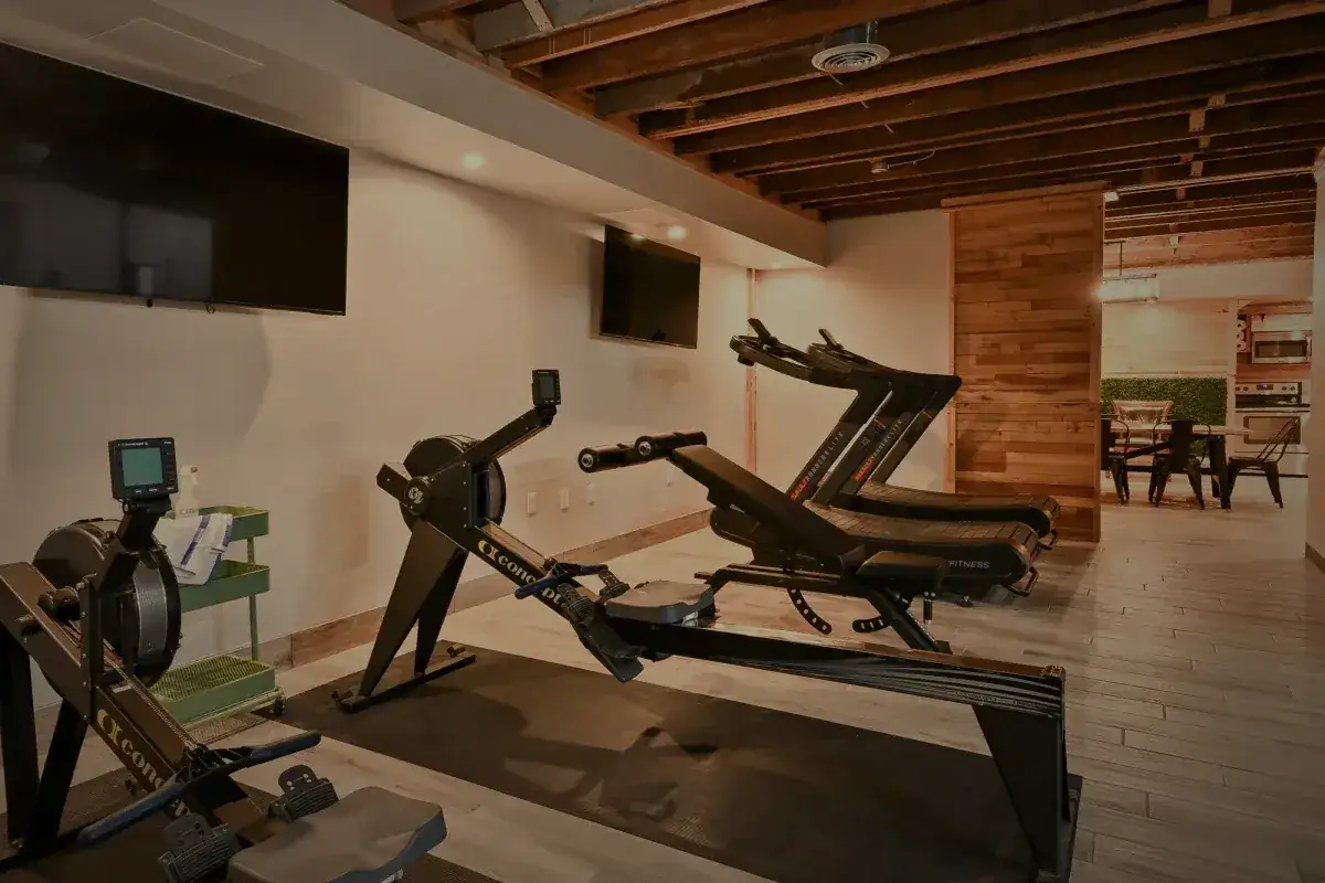 Rowing machines under the exposed timber beams, the long table beyond.