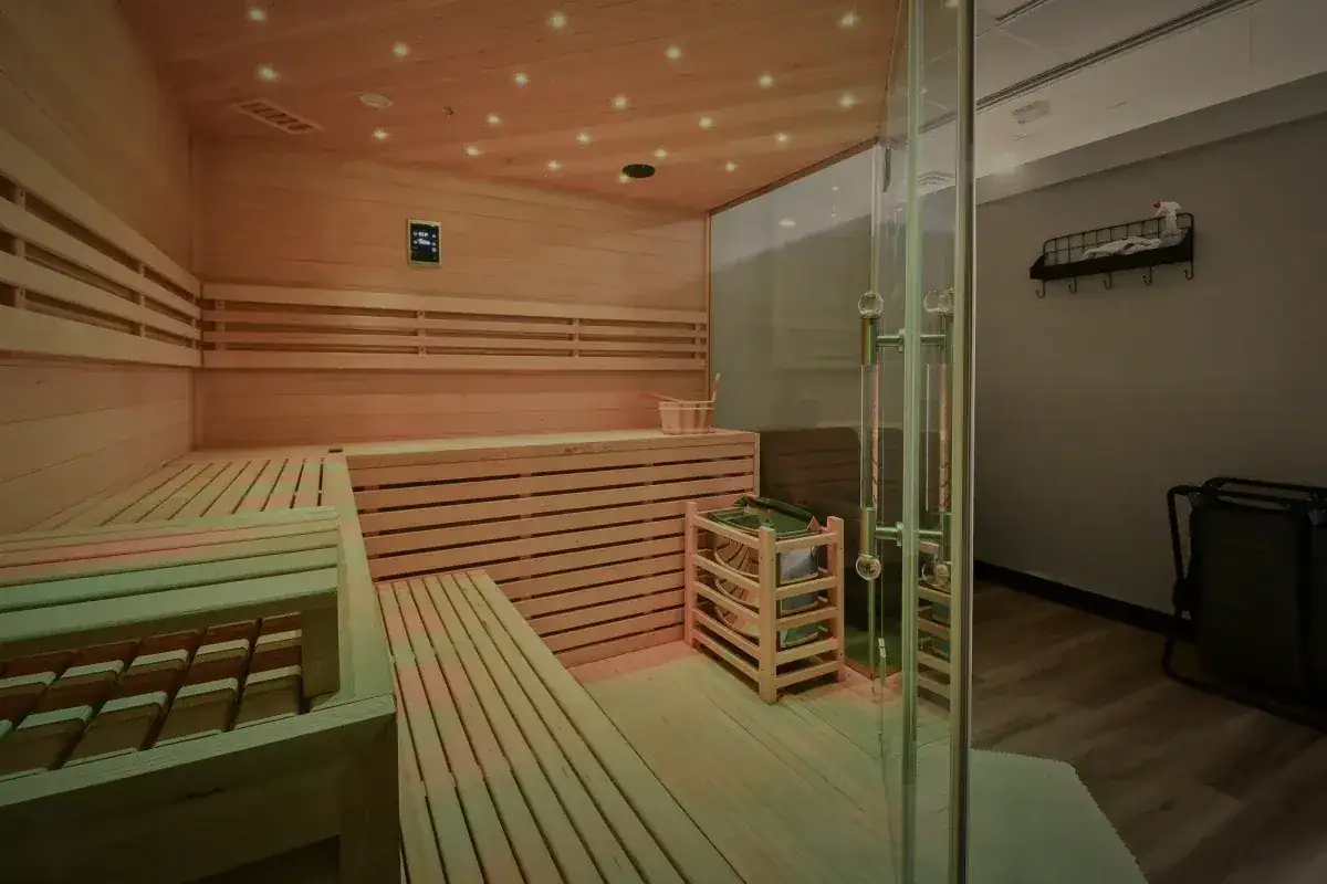 The cedar sauna, benches on two levels, lit from the ceiling.