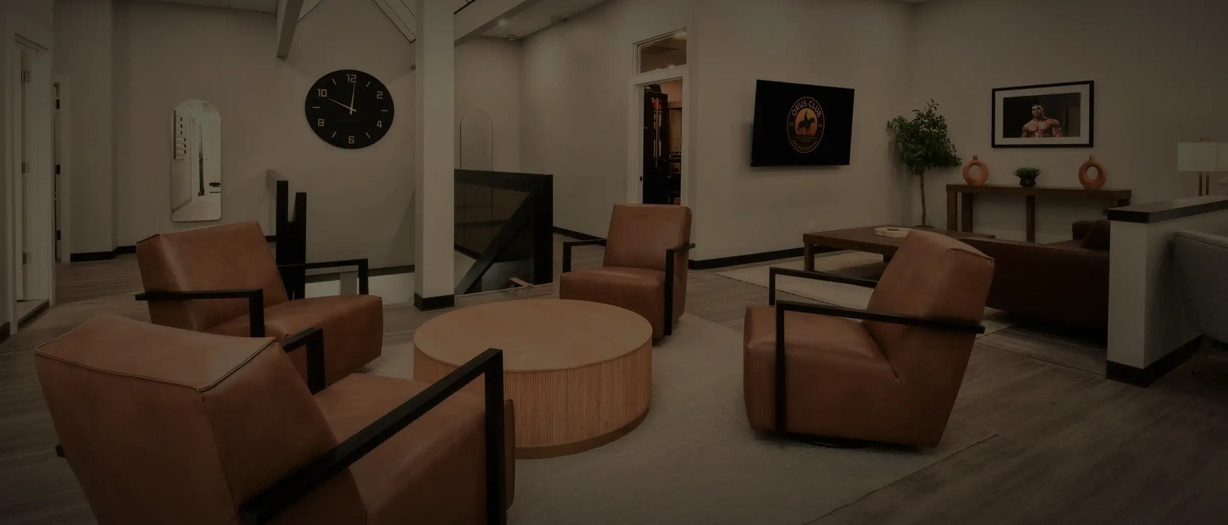 The main floor at Opus: leather chairs around a round oak table, the room opening past them.